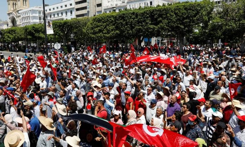 Demonstrators carry flags as they gather during a protest against President Saied in Tunis