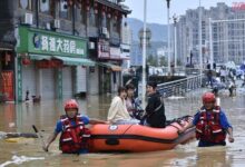 Rescuers use rubber dinghies to evacuate stranded people in flood water in Fujian province