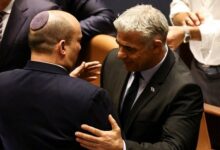 Naftali Bennett (left) and Yair Lapid embraced each other after the Knesset dissolution vote