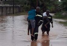 • Rescue team of the Fire Service carrying children through the floods