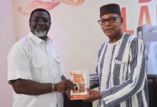 • Mr Andy Osei Ocran (left) presenting one of his books to Dr Ibn Chambas