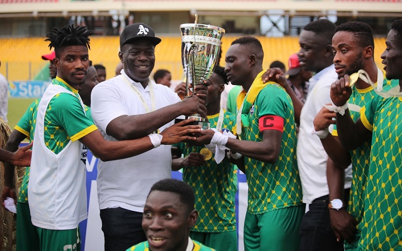 • Nsoatreman FC players presenting the trophy to Mr Baffour Awuah after their coronation