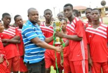 • Mr Mark Afenyo, an official of the school, presenting the cup to Abraham Sebie, captain of the red section team