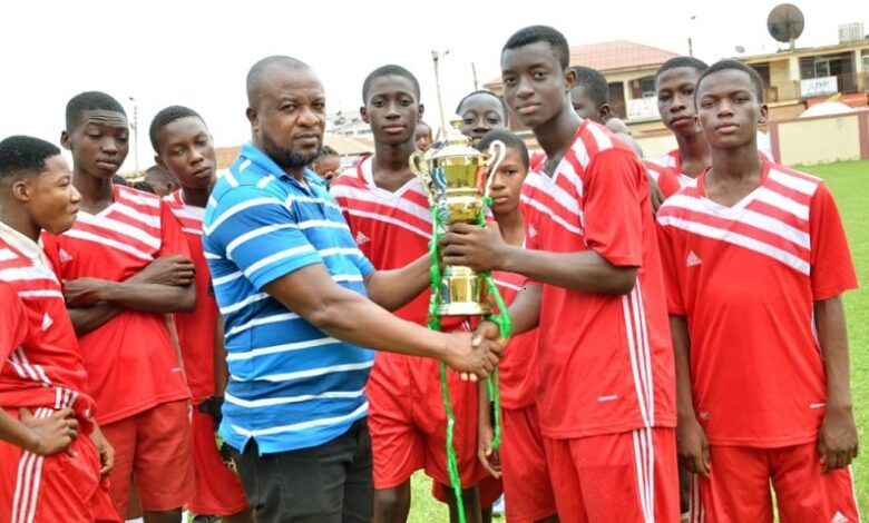 • Mr Mark Afenyo, an official of the school, presenting the cup to Abraham Sebie, captain of the red section team