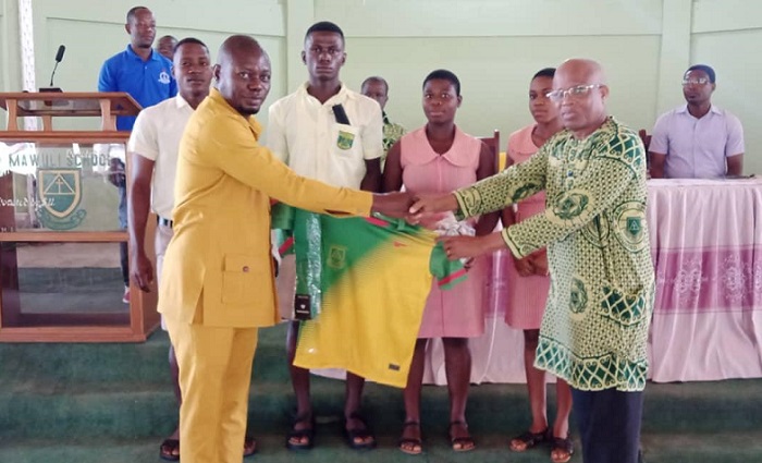• Mr Dartey (left) presenting one of the jerseys to the headmaster