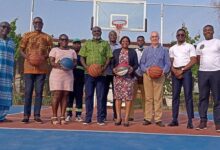 Officials at the ceremony pose on the basketball court after the unveiling