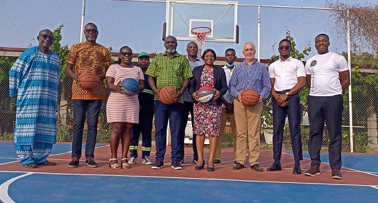 Officials at the ceremony pose on the basketball court after the unveiling