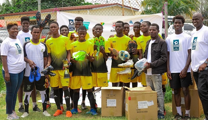 • Players of Take Heart FC pose with the trophy and equipment together with the Akwaboah family