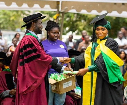 • Prof. Opoku Afriyie, Dean of School of Business, presenting a certificate to a graduand