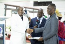 Reverend Emmanuel Teimah Barrigah (left) presenting a certificate to Apostle Immanuel Nii Okuley Tettey (right) behind them Reverend Paul Frimpong-Manso