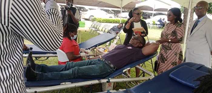 Dr Ofori (lying on bed) donating blood, while Dr Srofenyoh (right in suit) Dr Owusu-Ofori (third left) and other participants look on