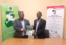 Mr. Ashaley (left) and Prof. Teitey shaking hands after signing the MoU