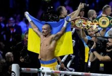 Usyk responding to cheers whilst displaying the Ukrainian flag after the fight