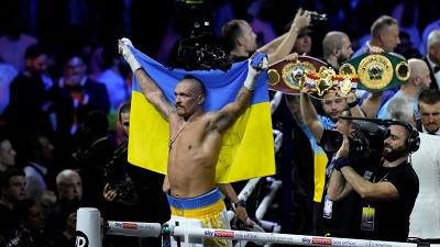 Usyk responding to cheers whilst displaying the Ukrainian flag after the fight