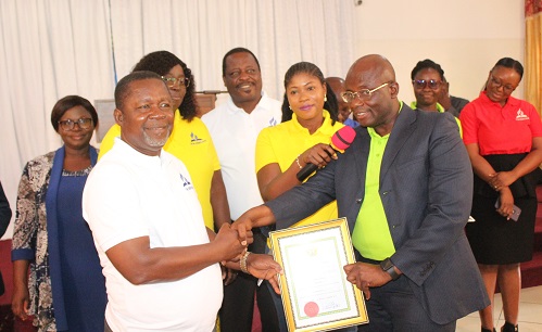 Mr Kwabena Yeboah Apraku (right),presenting the certificate of operation to Pastor. Dr Kwame Annor Boahen(left). With them are staff of AHCoF limited. Photo. Ebo Gorman