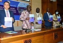 Professor Samuel K. Annim (middle) and other partners launching the report