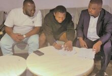 Alidu (centre) signing his contract