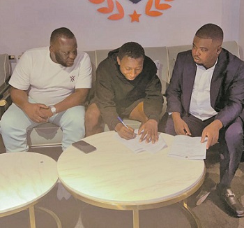 Alidu (centre) signing his contract