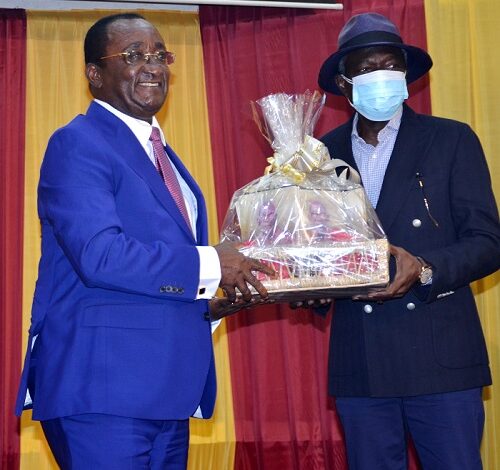 • .Dr Afriyie Akoto (left) presenting a parcel of books to the highest bidder Photo. Vincent Dzatse