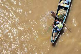 Residents navigate a boat across floodwater in N'djemena