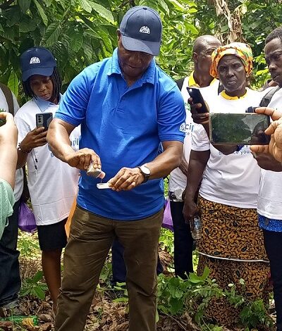 Mr Attivor demonstrating the testing of soil PH (acidity levels) on a farm to participants