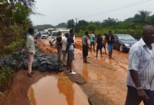 • The muddy road on Ewusiejoe section of the Agona-Takoradi highway showing the exposed boulders at the edges