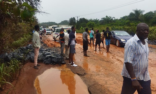 • The muddy road on Ewusiejoe section of the Agona-Takoradi highway showing the exposed boulders at the edges