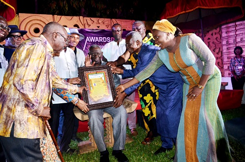 Former President Kufour(seated) receiving his award from Mr Kwame Pianim, Nana Kobina Nketsia and others