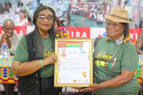 Madam Ethel Jacks, Ghana's table tennis queen (right) picks her award from the WISA President