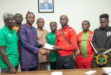 Deputy Minister of Youth and Sports Evans Opoku Bobie (second left) with the support of the Chief Accountant - Alhaji Osman Haruna Tweneboah (left) presenting the cheques to medal winners and coaches