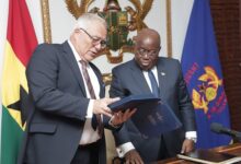 President Akufo-Addo (right), being shown a copy of a diary from the ICC by Piotr Hofmanski (left), President, (ICC)