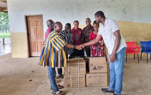 Mr. Elagbe, North Tongu District Public Health Nurse present items to Torgbe Gidi IV, Manklado of Torgorme Traditional Area(left) to be given to nurses at the Health Centre. Looking on are Dr Kofi Effah(third right) in the background with nurses