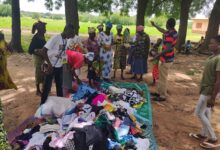 Mr Nchor and the beneficiaries inspecting the items