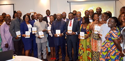 Dr Kweku Afriyie(middle) and other officials with the report during the launch. Photo. Vincent Dzatse