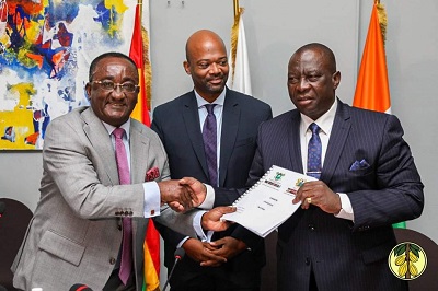 Dr Akoto (left) presenting the charter to Ivorian Minister of Agriculture and Rural Development,KobenaKouassiAdjoumani. Looking on is Alex Pierre-ArnauldAssanvo, the Executive secretary of the CIGCI