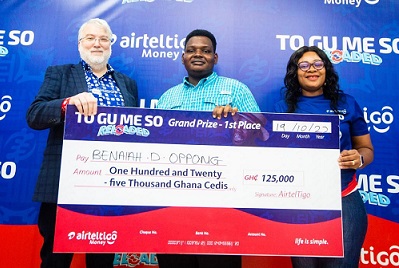 Mr Oppong (middle) with officials of AirtelTigo displaying the cheque
