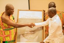 Odeneho Akoto III (left) presenting Azuma Nelson with a citation at the event