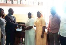 Mr Dwomoh-Ameyaw (third from left) presenting the cheque to Sr Arthur.