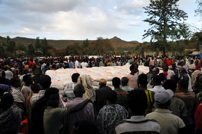 People stand in line to receive food donations at the Tsehaye primary school