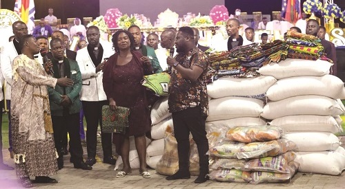 Apostle Agyemang (left) presenting the items to the needy.
