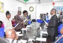 Dr Eric Oduro Osae (right) swearing-in the new members in to office