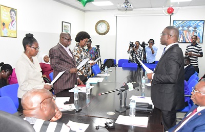 Dr Eric Oduro Osae (right) swearing-in the new members in to office