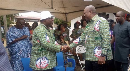 Former President John Mahama, (right) exchanging greetings with the Moderator