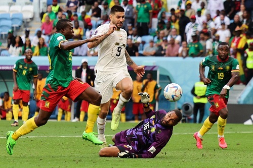 Serbia forward Aleksandar Mitrovic hit the ball pass goalkeeper Devis Epassy while Nouhou Tolo and Collins Fai close in