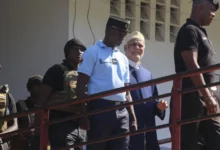Former Comorian President Ahmed AbdallahSambi (2nd R), escorted by gendarmes, arrives at the courthouse in Moroni in this file photo taken on November 21, 2022