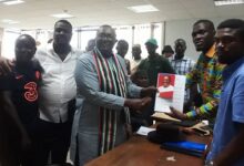 Nii Armah Ashitey (3rd from left) presenting the forms to Mr Sebbie T. Vincent, Assistant to the Election Director.