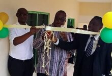 • Mr Abazing (right) cutting tape to open the classroom block (inset)