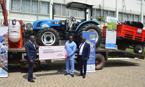 Mr Isaac Amissah Aidoo (second from right) presenting the dummy cheque to Mr Yaw Frimpong Addo(left) at the background is the tractor with its trailor. Photo: Vincent Dzatse