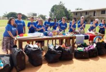 Ms Condello (left) speaking at the donation, with her are her collegues with the items in front - Copy