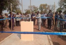 Elder Richard Amaning cutting the tape to commission the borehole